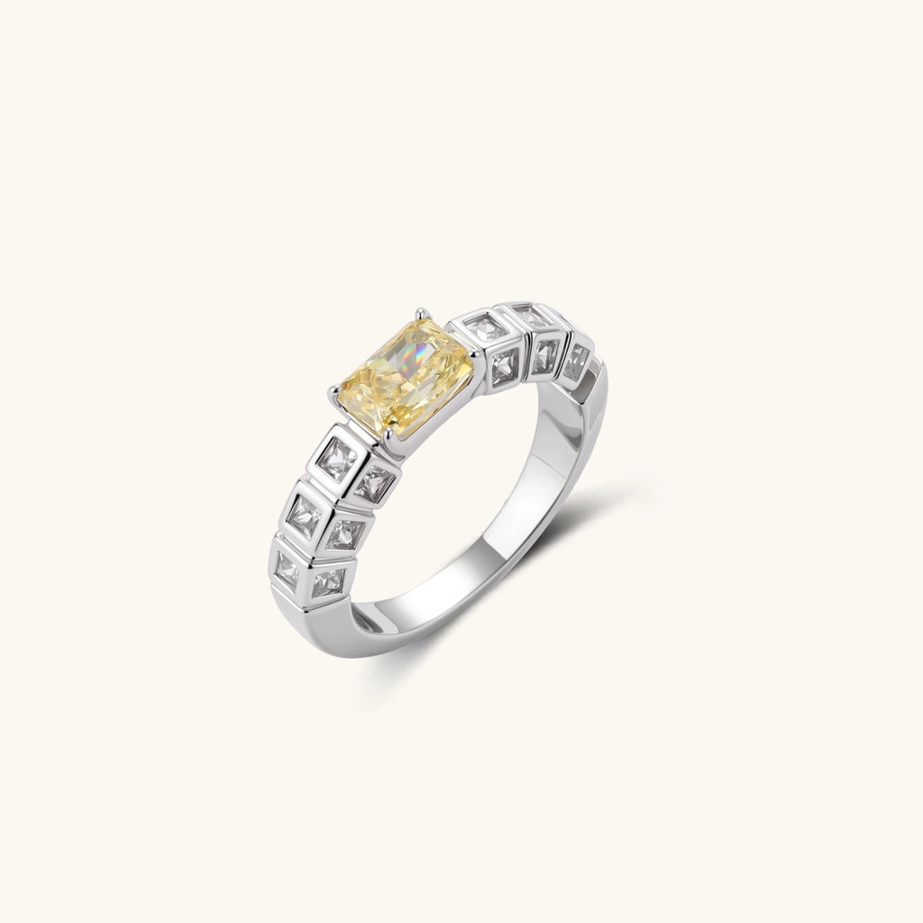 Adjustable ring with emerald-cut yellow zirconia center and clear accent stones in geometric platinum-plated setting